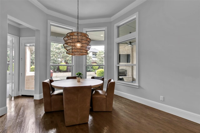 dining room featuring baseboards, ornamental molding, a notable chandelier, and dark wood-type flooring