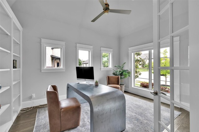 office with a ceiling fan, a high ceiling, baseboards, and dark wood-type flooring