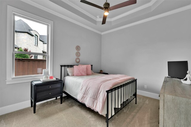 bedroom with crown molding, carpet floors, baseboards, and a tray ceiling