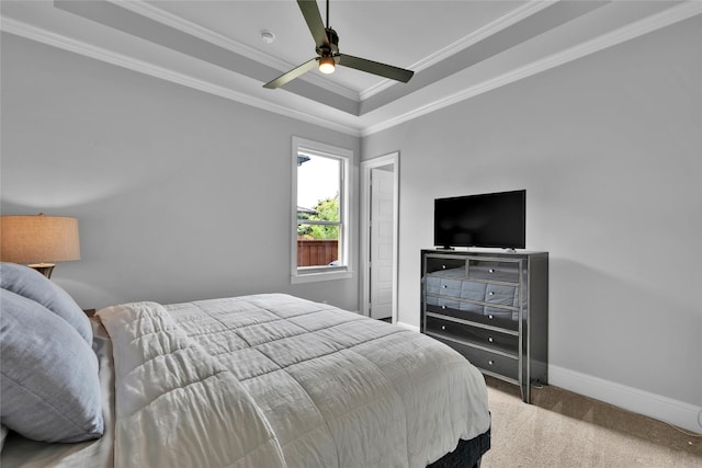 carpeted bedroom with baseboards, ornamental molding, ceiling fan, and a tray ceiling