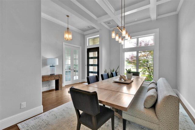 dining space featuring crown molding, beam ceiling, baseboards, a chandelier, and coffered ceiling