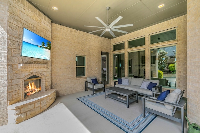 view of patio / terrace with a ceiling fan and an outdoor living space with a fireplace