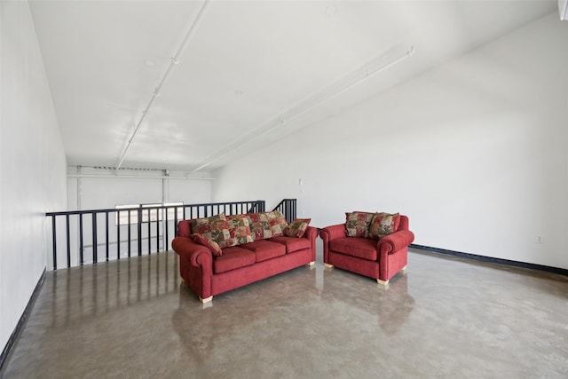 living room featuring concrete flooring and baseboards