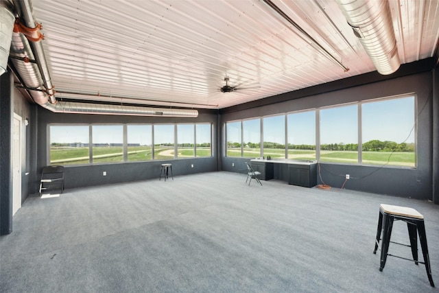 sunroom with a ceiling fan and golf course view