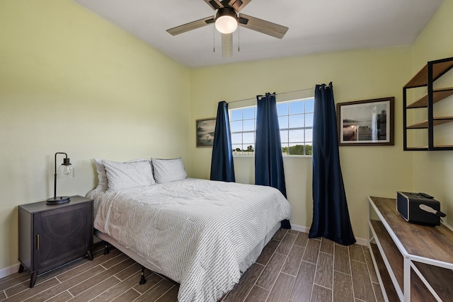 bedroom with baseboards, a ceiling fan, and wood tiled floor