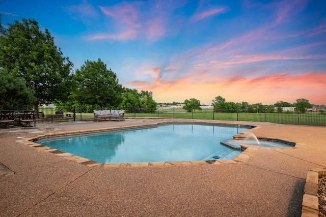 pool at dusk featuring fence, a patio area, and a fenced in pool