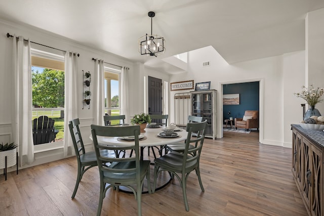 dining area featuring a chandelier, visible vents, wood finished floors, and baseboards