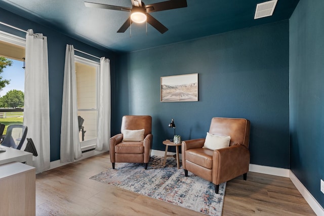 sitting room featuring visible vents, ceiling fan, wood finished floors, and baseboards