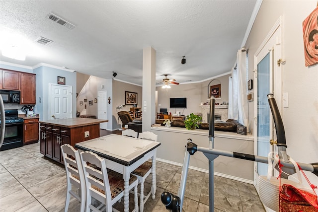 kitchen featuring black appliances, visible vents, a ceiling fan, and a center island