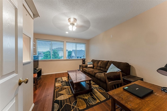 living area featuring a textured ceiling, ceiling fan, and dark wood-style flooring
