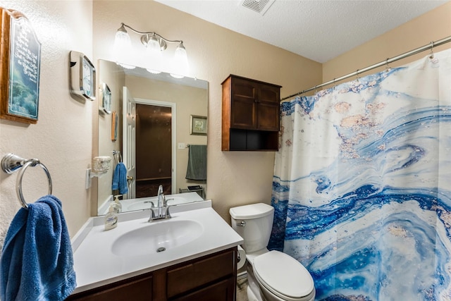 full bathroom featuring vanity, toilet, visible vents, a textured wall, and a textured ceiling