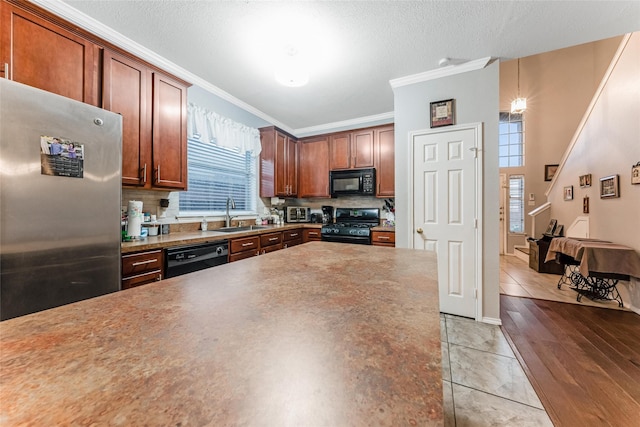 kitchen featuring black appliances, backsplash, ornamental molding, a sink, and a textured ceiling