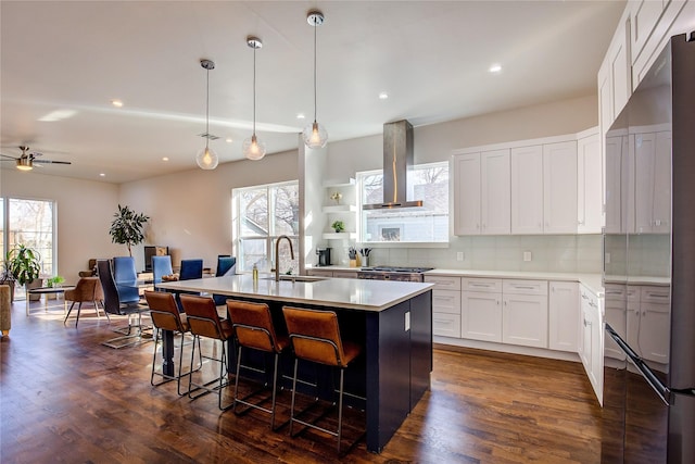 6702 Tyree St, Dallas, TX 75209 - kitchen featuring extractor fan, a sink, a kitchen island with sink, tasteful backsplash, and a breakfast bar