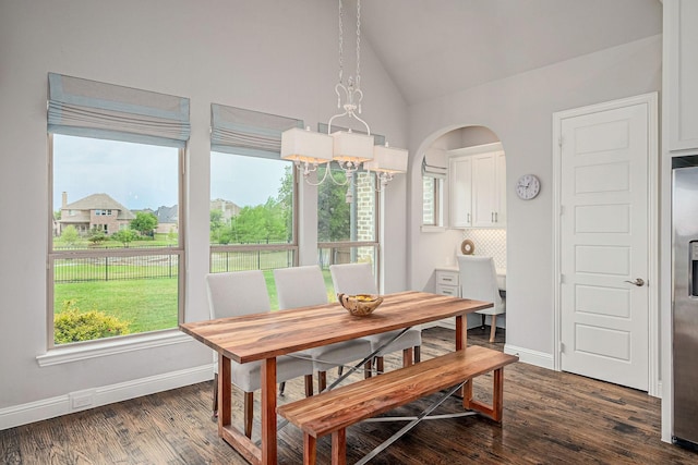 dining area featuring baseboards, dark wood finished floors, a healthy amount of sunlight, and lofted ceiling
