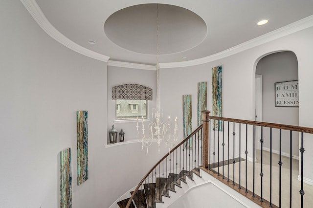 stairway with crown molding, recessed lighting, and arched walkways