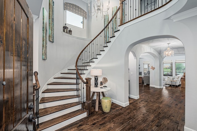 entrance foyer with stairs, wood finished floors, and a notable chandelier