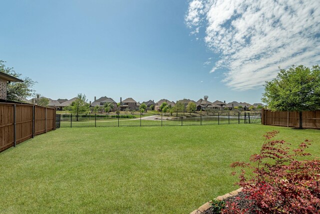 view of yard with a residential view and a fenced backyard
