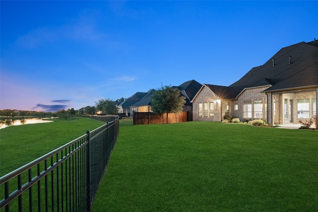 view of yard featuring a water view and fence