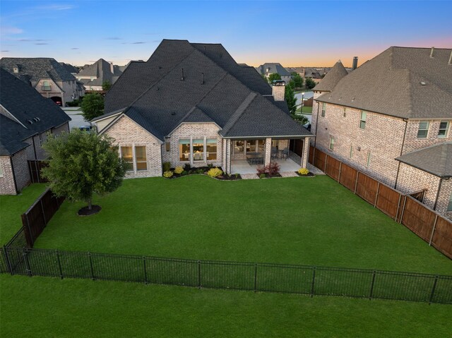 back of house featuring a patio, a fenced backyard, and a chimney