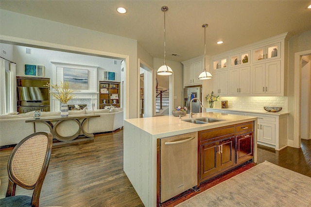 kitchen featuring dark wood finished floors, light countertops, backsplash, a sink, and open floor plan