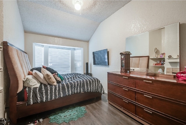 bedroom with a textured ceiling, a textured wall, wood finished floors, and lofted ceiling