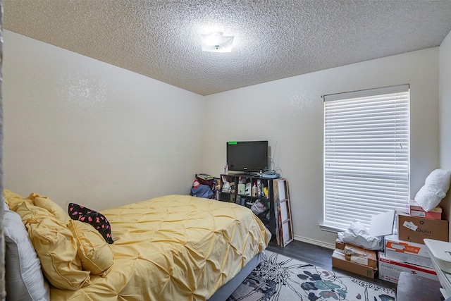 bedroom with a textured ceiling and wood finished floors