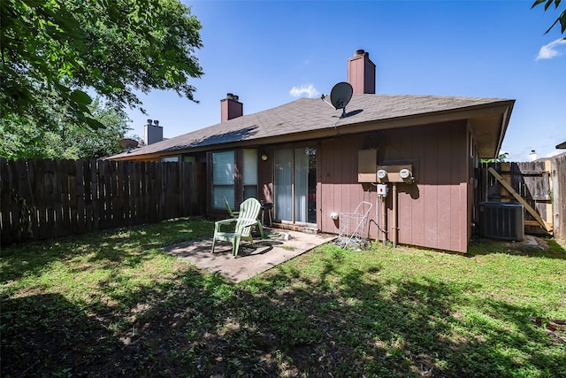 rear view of house featuring a patio, a fenced backyard, a yard, and cooling unit