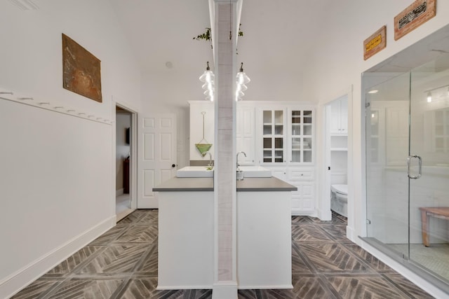 334 Pleasant Acres Rd, Rockwall, TX 75087 - kitchen featuring white cabinets, dark countertops, glass insert cabinets, and a sink