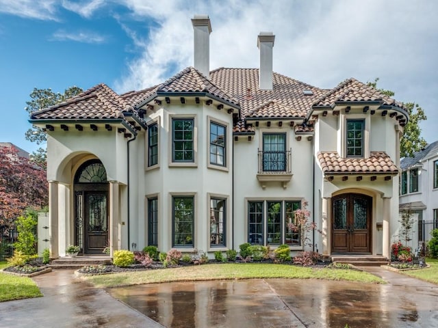 view of front of house with a chimney, french doors, stucco siding, and a tile roof