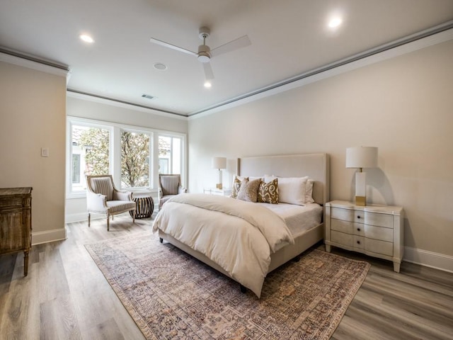 bedroom featuring crown molding, visible vents, wood finished floors, and baseboards