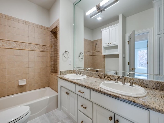 full bathroom with toilet, double vanity, a sink, and  shower combination