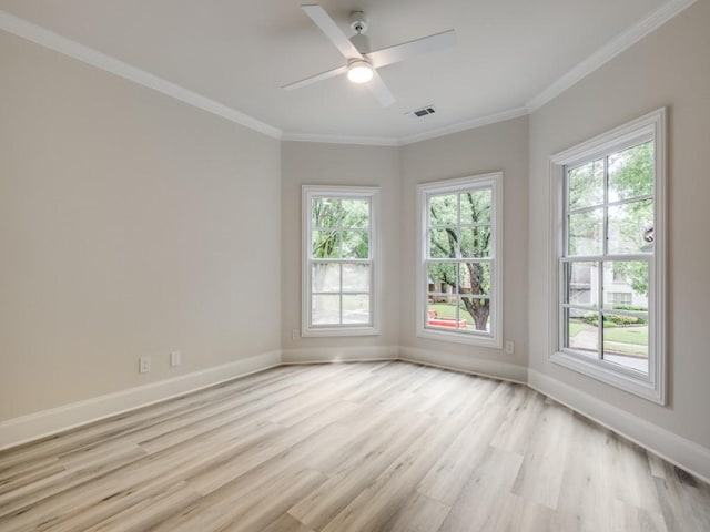 empty room featuring crown molding, plenty of natural light, baseboards, and light wood-type flooring