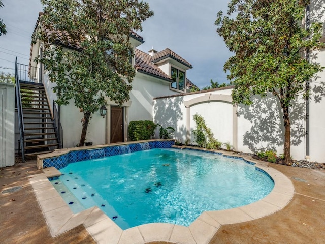 view of pool with stairway and a fenced in pool