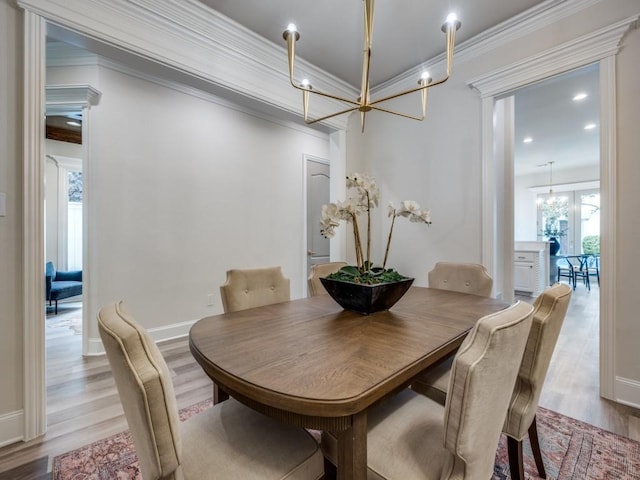 dining area with ornamental molding, wood finished floors, a notable chandelier, and baseboards