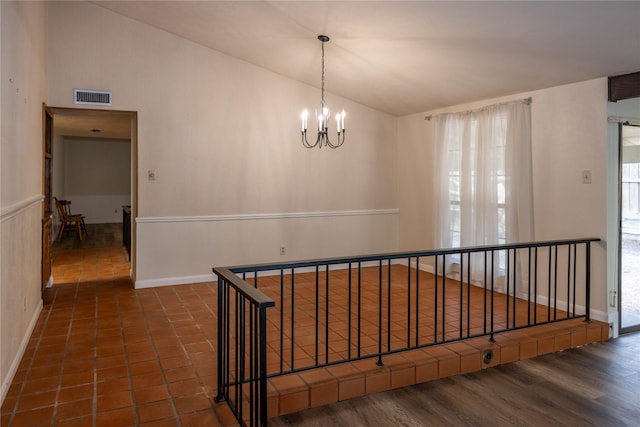 hall with baseboards, visible vents, a notable chandelier, and vaulted ceiling