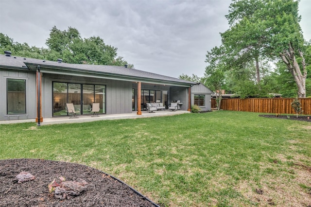 back of house featuring a patio, a lawn, board and batten siding, an outdoor hangout area, and fence