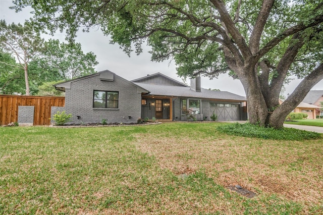 ranch-style home with a chimney, brick siding, fence, a garage, and a front yard