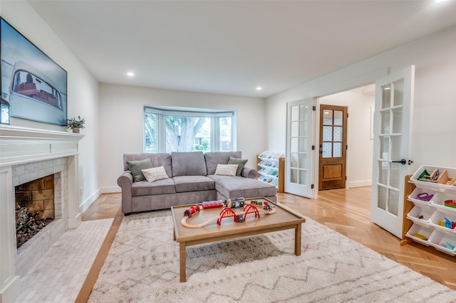 living room with a tile fireplace, french doors, recessed lighting, and baseboards