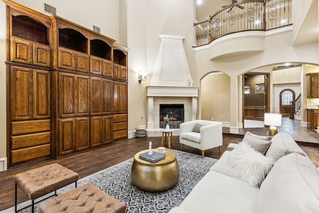 1233 Deer Lake Dr, Frisco, TX 75036 - living area with a towering ceiling, arched walkways, and dark wood-style floors