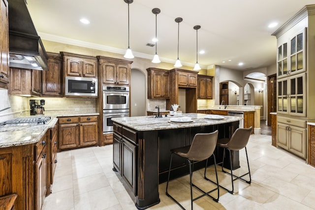 1233 Deer Lake Dr, Frisco, TX 75036 - kitchen featuring stainless steel appliances, a center island with sink, arched walkways, decorative backsplash, and premium range hood