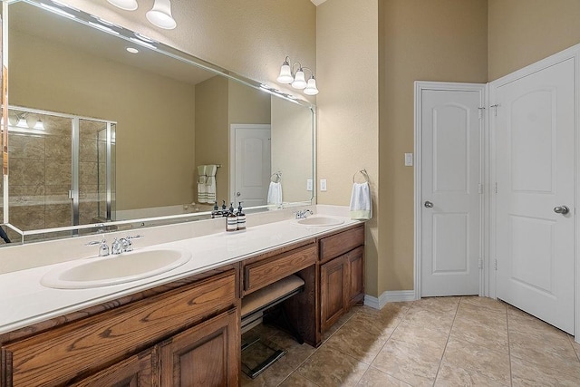 bathroom with tile patterned floors, a stall shower, double vanity, and a sink