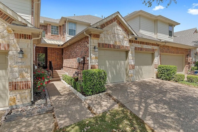 view of front of home featuring concrete driveway, stone siding, a shingled roof, and brick siding