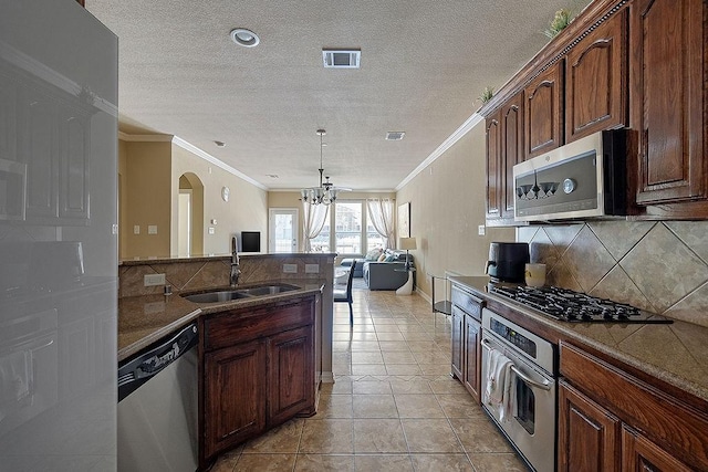 kitchen with an inviting chandelier, stainless steel appliances, backsplash, a sink, and visible vents