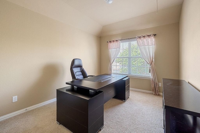 office featuring lofted ceiling, baseboards, and light carpet
