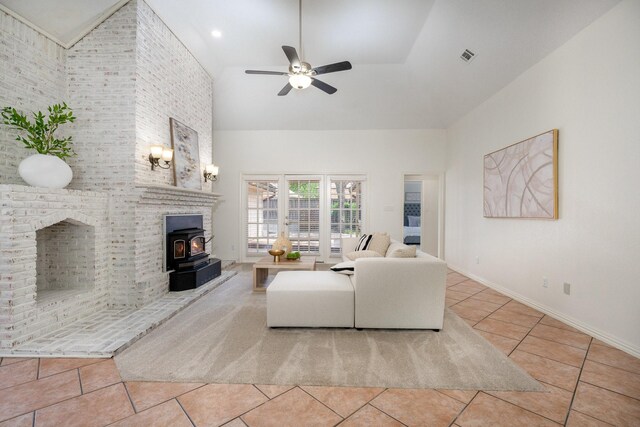 4703 El Brevo Ct, Arlington, TX 76017 - living area featuring a wood stove, a towering ceiling, tile patterned flooring, and a ceiling fan