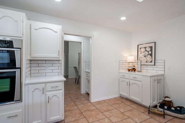 4703 El Brevo Ct, Arlington, TX 76017 - kitchen with tasteful backsplash, stainless steel double oven, white cabinets, and light countertops