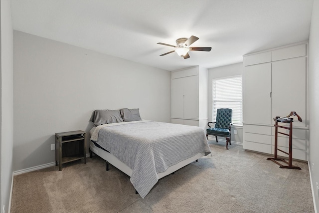 bedroom with a ceiling fan, baseboards, and light carpet