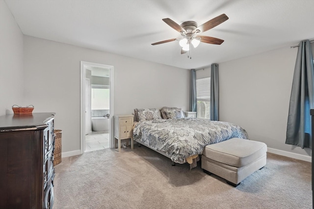 bedroom featuring carpet floors, a ceiling fan, ensuite bath, and multiple windows