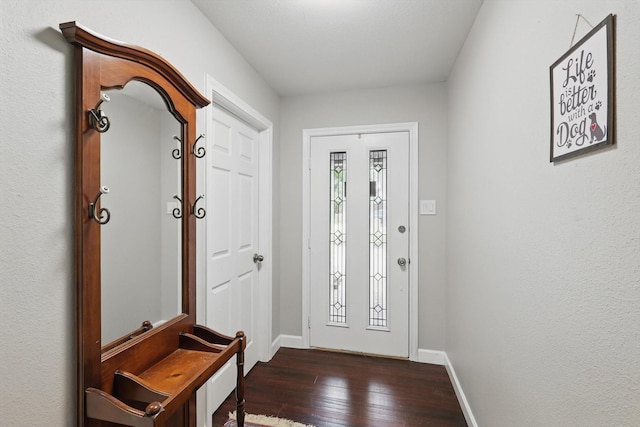entryway with dark wood finished floors and baseboards