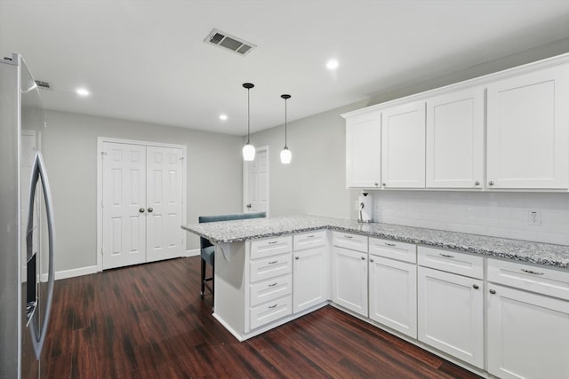 kitchen featuring white cabinetry, visible vents, dark wood finished floors, a peninsula, and stainless steel fridge